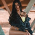 woman-in-black-and-yellow-dress-sitting-on-brown-wooden-bench-during-daytime-kb4k2mngnp0