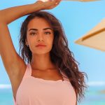 Girl in a pink dress under the beach umbrella